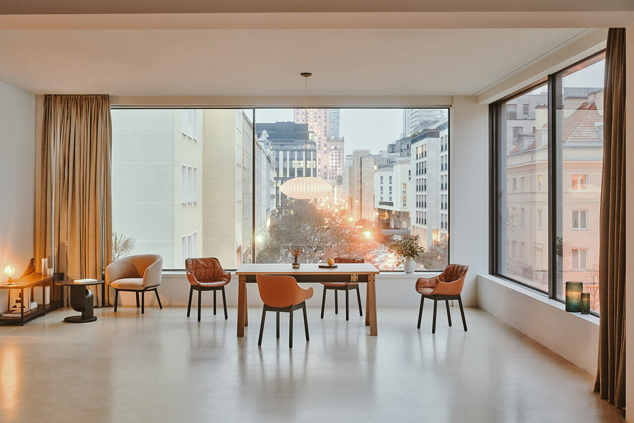 Elegant conference room with a large table, modern chairs and a panoramic view of the city through tall windows.