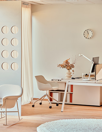 Home office in light tones with Ogi desk, Baltic chair and round rug in a muted interior.
